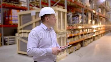 员工男仓库工人工程师戴安全帽在施工现场仓库工作，在物流中行走